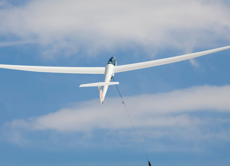 Glider aircraft in flight attached to a high-performance synthetic towing rope
